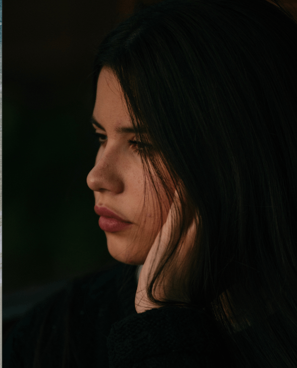 Image of woman holding her jaw like she as jaw pain in front of black background