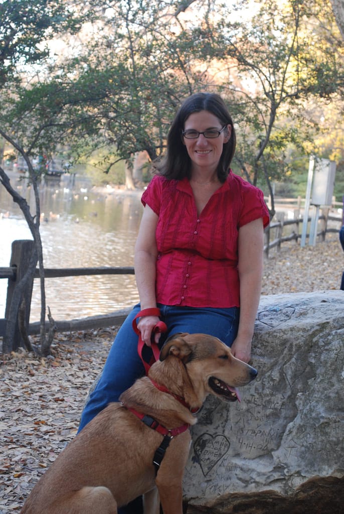 Photo of Beth Patton, fort worth massage therapist, with her dog, in front of a lake
