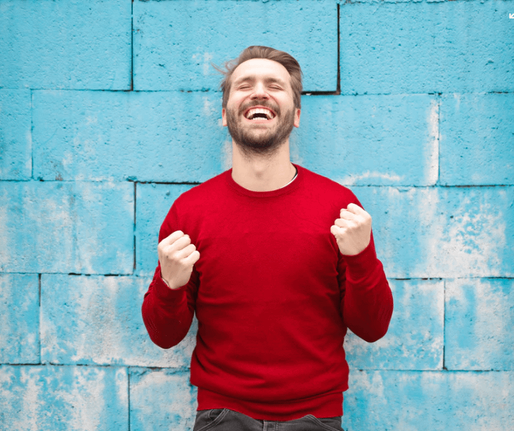 Image of man wearing a red shirt in front of a blue wall